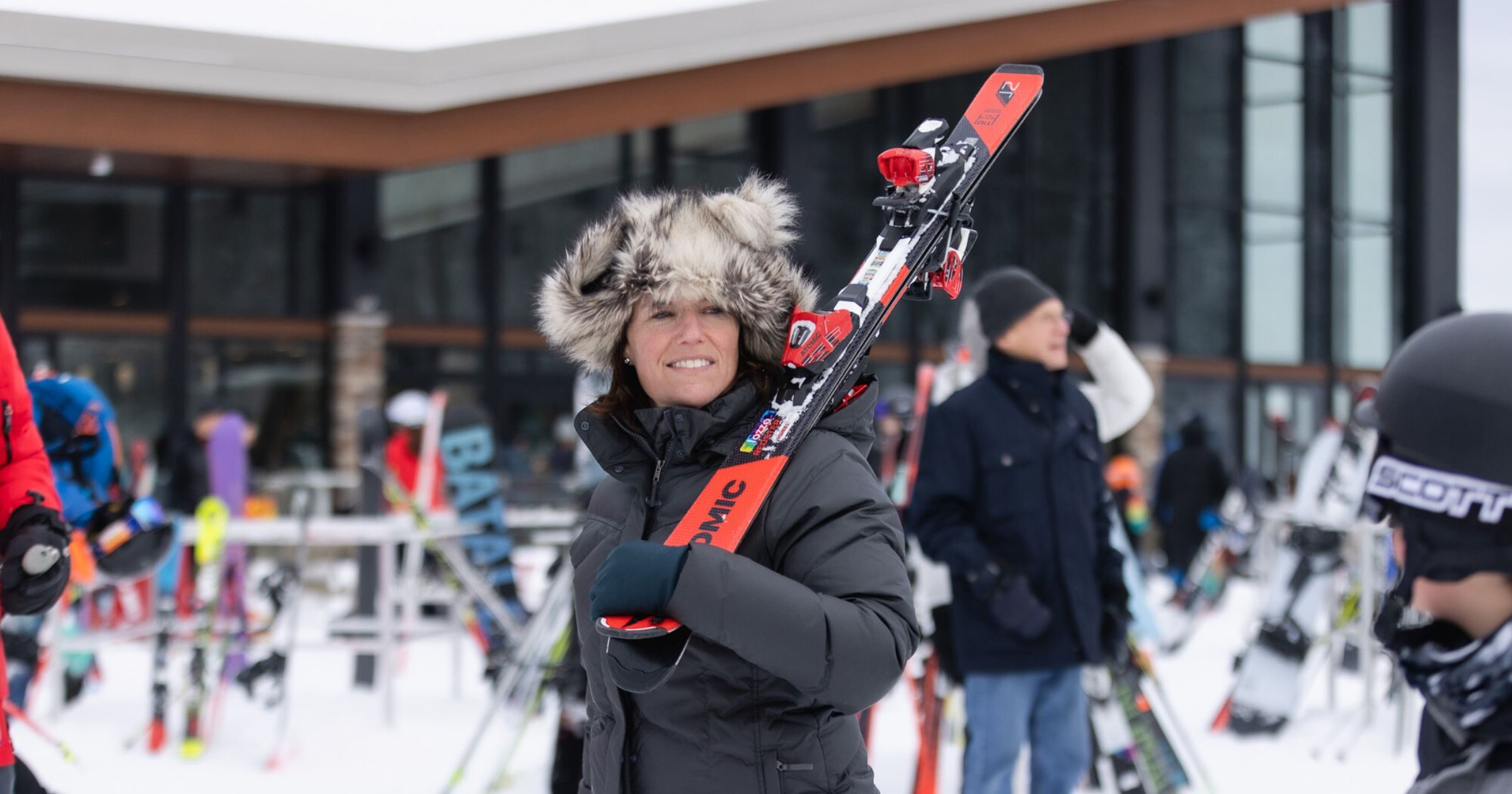 female-member-carrying-skis-happy